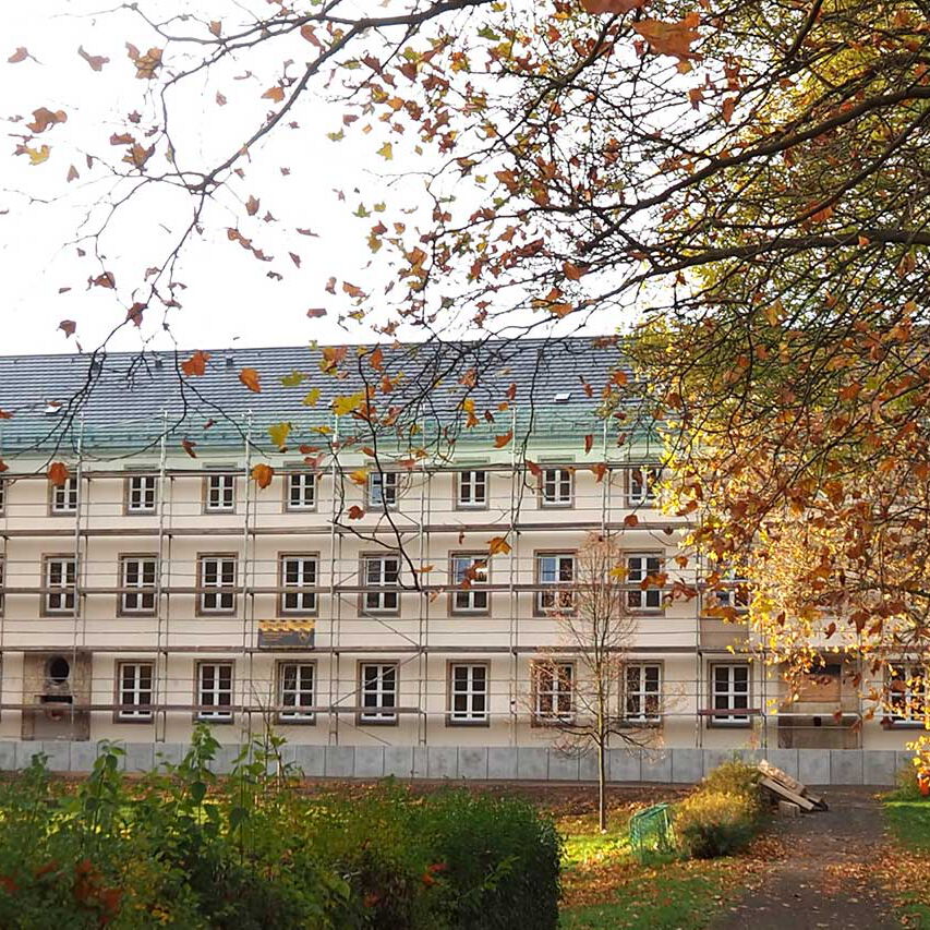 Das Gebäude mit Gerüst, neuer Fassade und Dach.