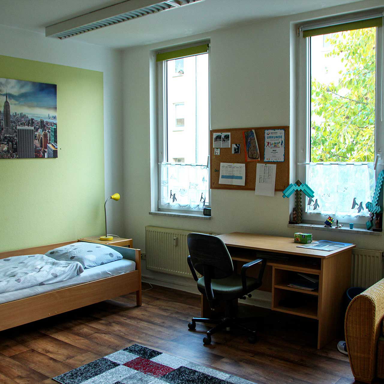 Ein Jugendzimmer mit Bett, Schreibtisch und einem Sofa.