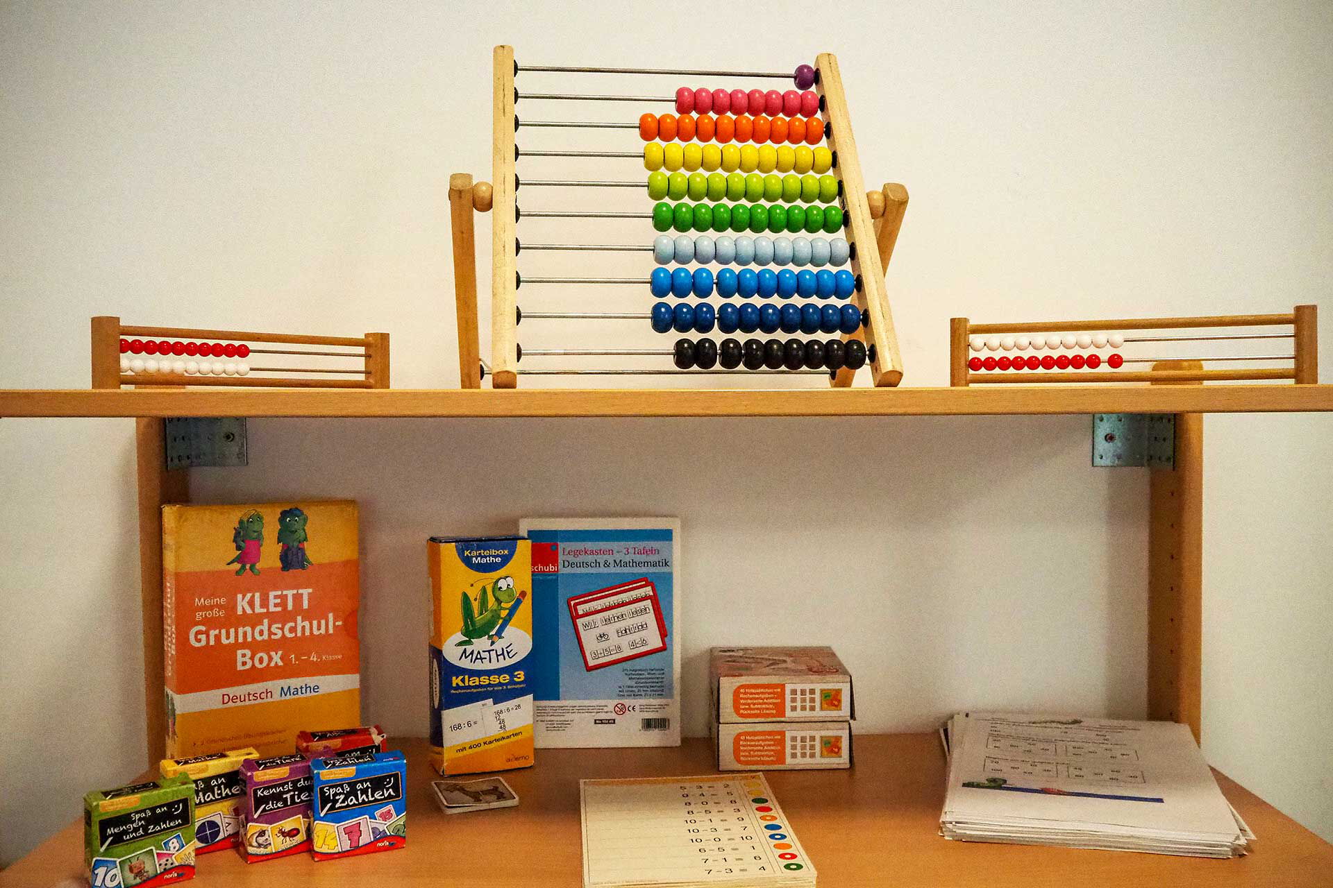 Mathematik Ein Wandregal mit vielen Matheaufgaben und Rechenschiebern.