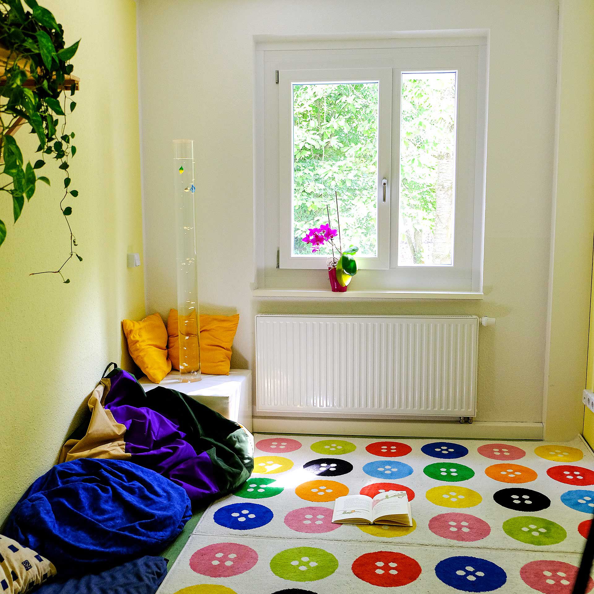 Ein Zimmer mit 3 Sitzsäcken und einem bunten Teppich.