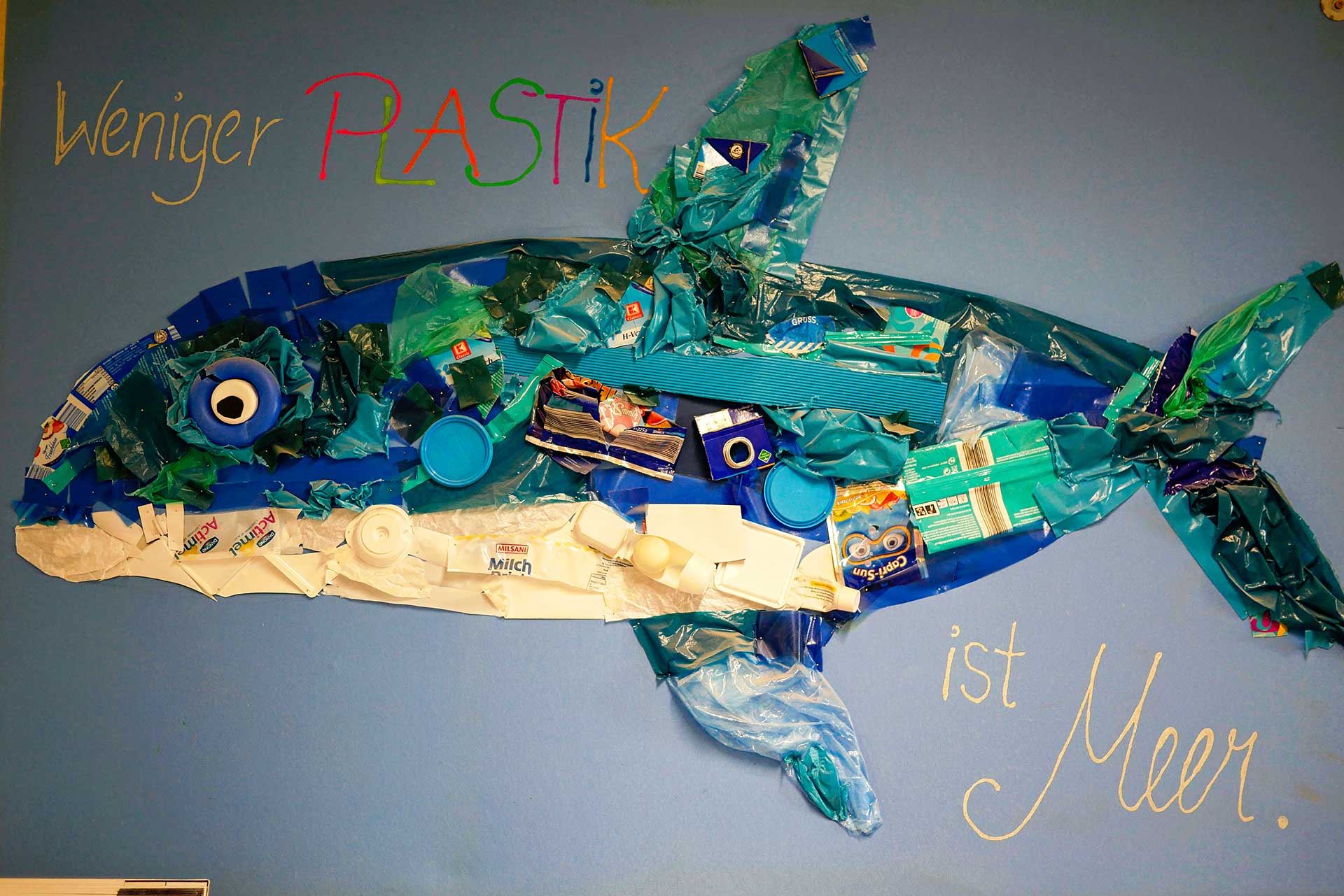 Umweltprojekt Ein selbstgebastelter Wal aus Plastikabfällen mit der Aufschrift: Weniger Plastik ist Meer.